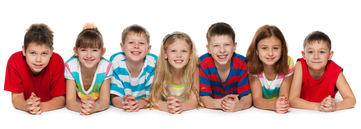 Seven children are lying on the floor on a white background